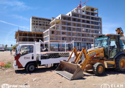 Camión FAW de carga ligera con plataforma, trabajando en una obra de construcción